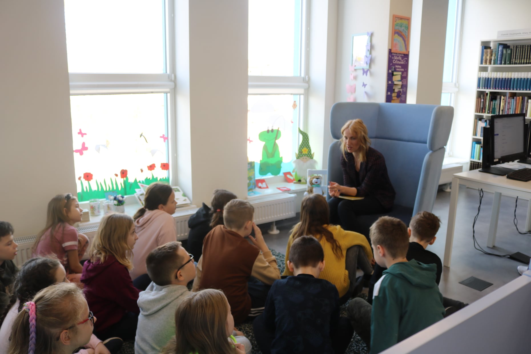 Dzieci słuchające podstawowych informacji o zasadach korzystania z biblioteki i księgozbioru